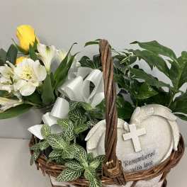 Basket arrangement with yellow and white flowers and a memorial plaque