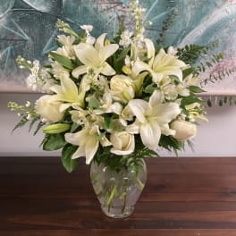 Cream-colored flowers arranged in a clear glass vase