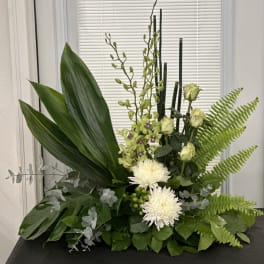 Green floral arrangement with white blooms and tall stems
