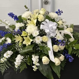 Large white and blue floral spray with a white ribbon bow