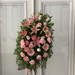 Pink floral standing spray with lilies, carnations, and daisies
