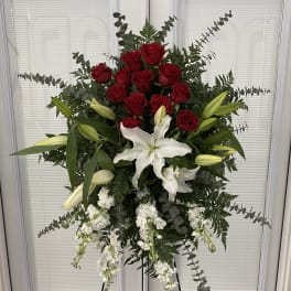 Standing floral spray with red roses, white lilies, and white blooms