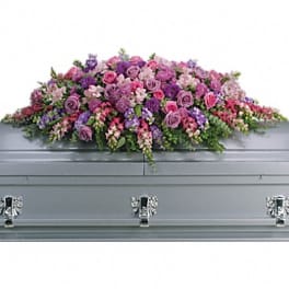 Pink and purple floral spray on a silver casket