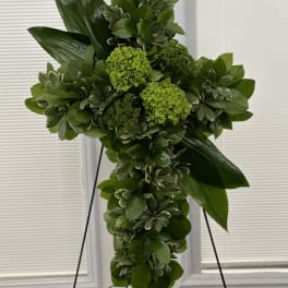 Green floral cross on a black stand