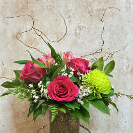 Pink roses and alstroemeria in a textured vase with bright green chrysanthemum