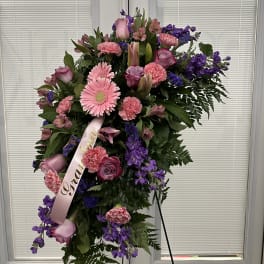 Standing floral spray with pink and purple flowers on an easel