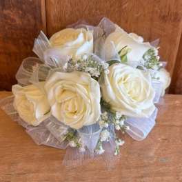 Bouquet of white roses with small white filler flowers and sheer ribbon wrap
