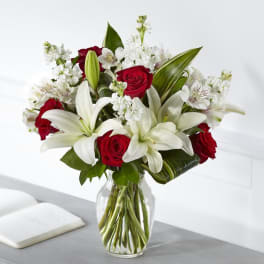 Red roses and white lilies arranged in a clear glass vase
