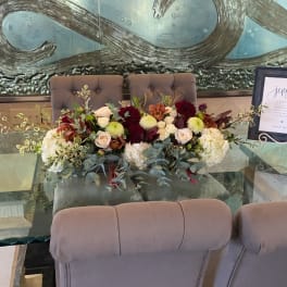 Low floral centerpiece with roses and mums on a table