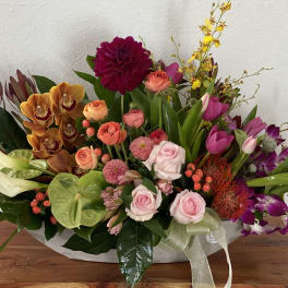 Colorful mixed flower arrangement in a low white container