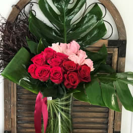 Bouquet of red and pink roses in a clear glass vase