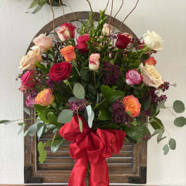 Mixed rose bouquet with a large red ribbon bow