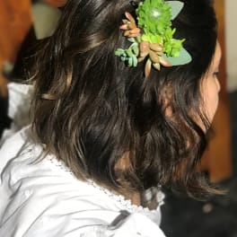 Woman with a green succulent hair clip in dark hair