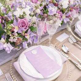 Lavender and white floral table centerpiece with place settings