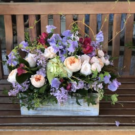 Mixed bouquet of lavender and peach flowers in a rustic wooden box