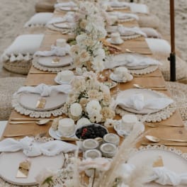 Long banquet table with white floral centerpieces and place settings