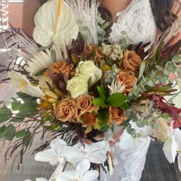 Bride holding a large bouquet with white orchids and tan roses