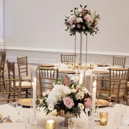 Floral centerpieces with pink and white roses on a banquet table