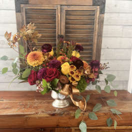 Mixed bouquet in a silver vase with red, yellow, and orange flowers