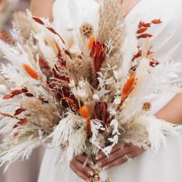 Bride holding a dried bouquet with white and rust accents