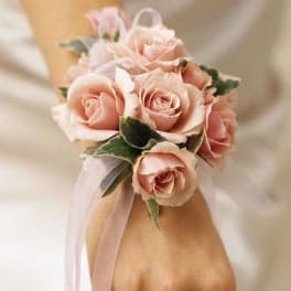Pink rose wrist corsage with ribbon on a wrist