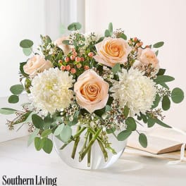 Peach roses and white mums in a clear glass vase
