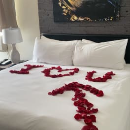 Bed decorated with red rose petals spelling "I LOVE U"
