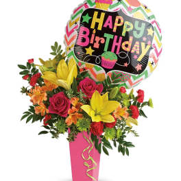 Birthday bouquet with roses, lilies, and a balloon in a pink vase