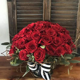 Large bouquet of red roses with a black-and-white ribbon