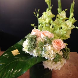 Arrangement of peach roses and white flowers in a black vase