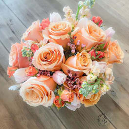 Bouquet of peach roses with small pink and white accent flowers