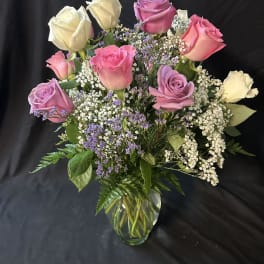 Bouquet of pink, lavender, and white roses in a glass vase