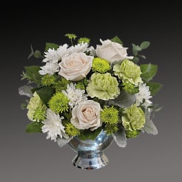 Bouquet of cream roses, white daisies, and green carnations in a silver vase