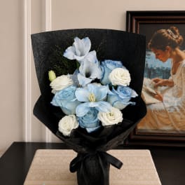 Blue and white bouquet wrapped in black paper with a ribbon