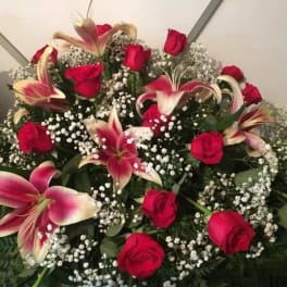 Arrangement of red roses and pink lilies with baby's breath