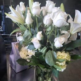 White roses and lilies arranged in a glass vase