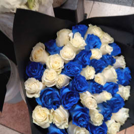 Bouquet of blue and white roses wrapped in black paper