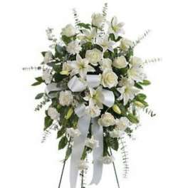 White floral standing spray with ribbon on an easel