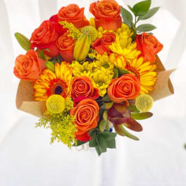 Bouquet of orange roses and yellow daisies wrapped in brown paper