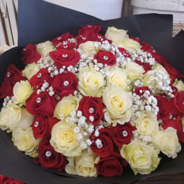 Bouquet of red and white roses with baby's breath in black wrap