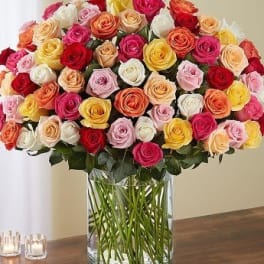 Large bouquet of multicolored roses in a clear glass vase