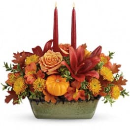 Autumn floral centerpiece with red candles in a rectangular vase