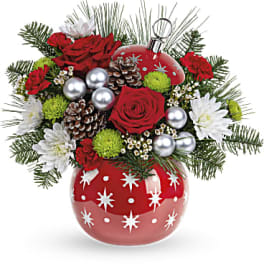 Red roses and white flowers in a red ornament vase with pinecones
