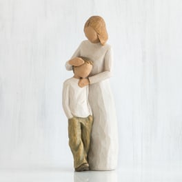 Wooden figurine of a woman embracing a child