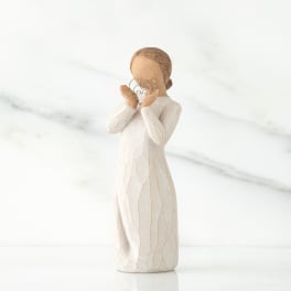 Figurine of a girl in a white dress holding heart shapes