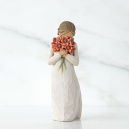 Figurine of a girl holding an orange flower bouquet