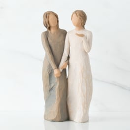 Two faceless carved figurines standing side by side