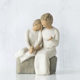Two carved figurines seated together on a stone-like base