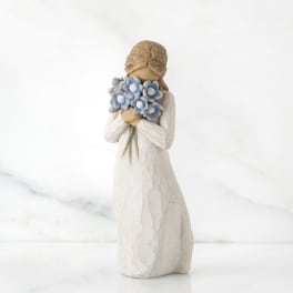 Carved figurine of a girl holding a bouquet of blue flowers