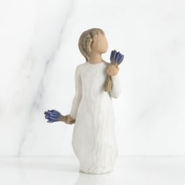 Small figurine of a girl holding blue flowers